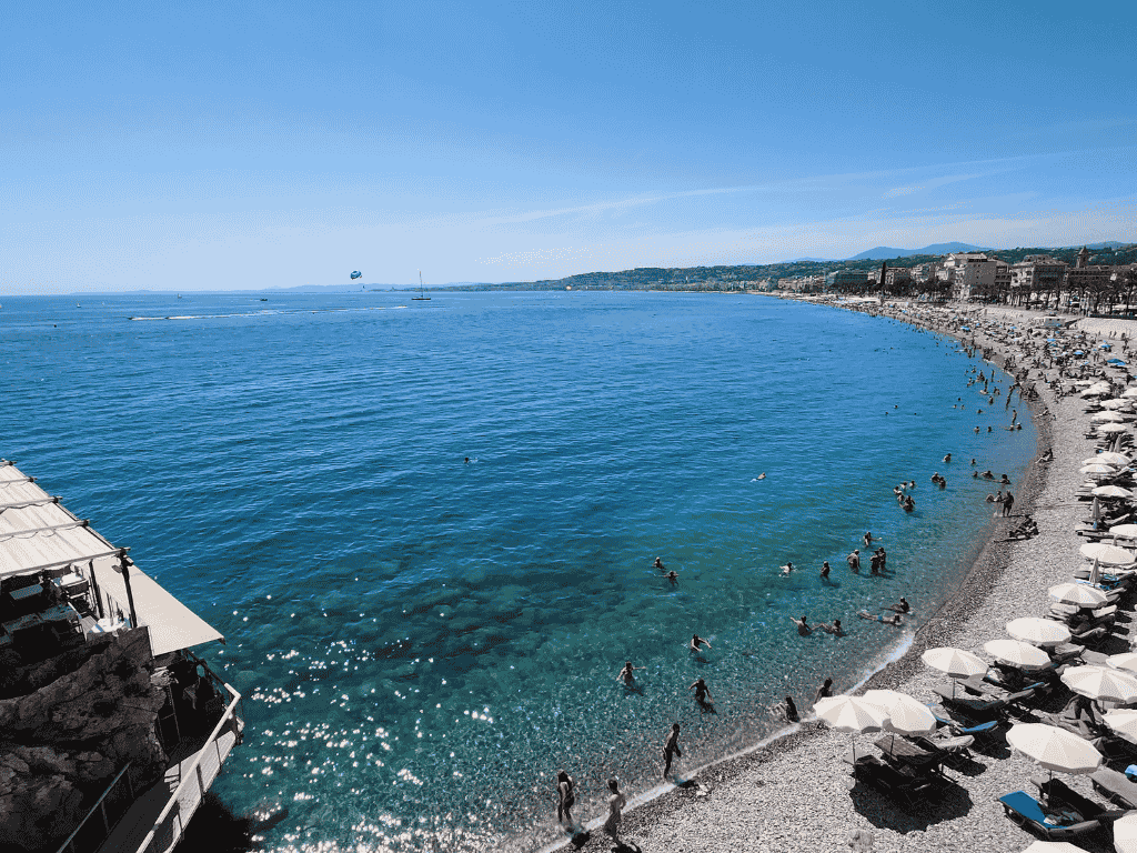 Nice beach on the Promenade des Anglais with people enjoying the Mediterranean sea on the French Riviera