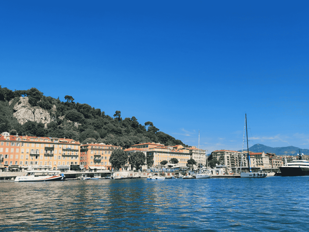 Waterfront buildings at Nice Port Lympia with boats and Castle Hill on the French Riviera